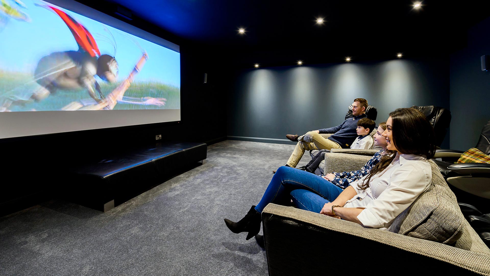 Family in a private cinema room watching cartoon on screen at Cork International Hotel