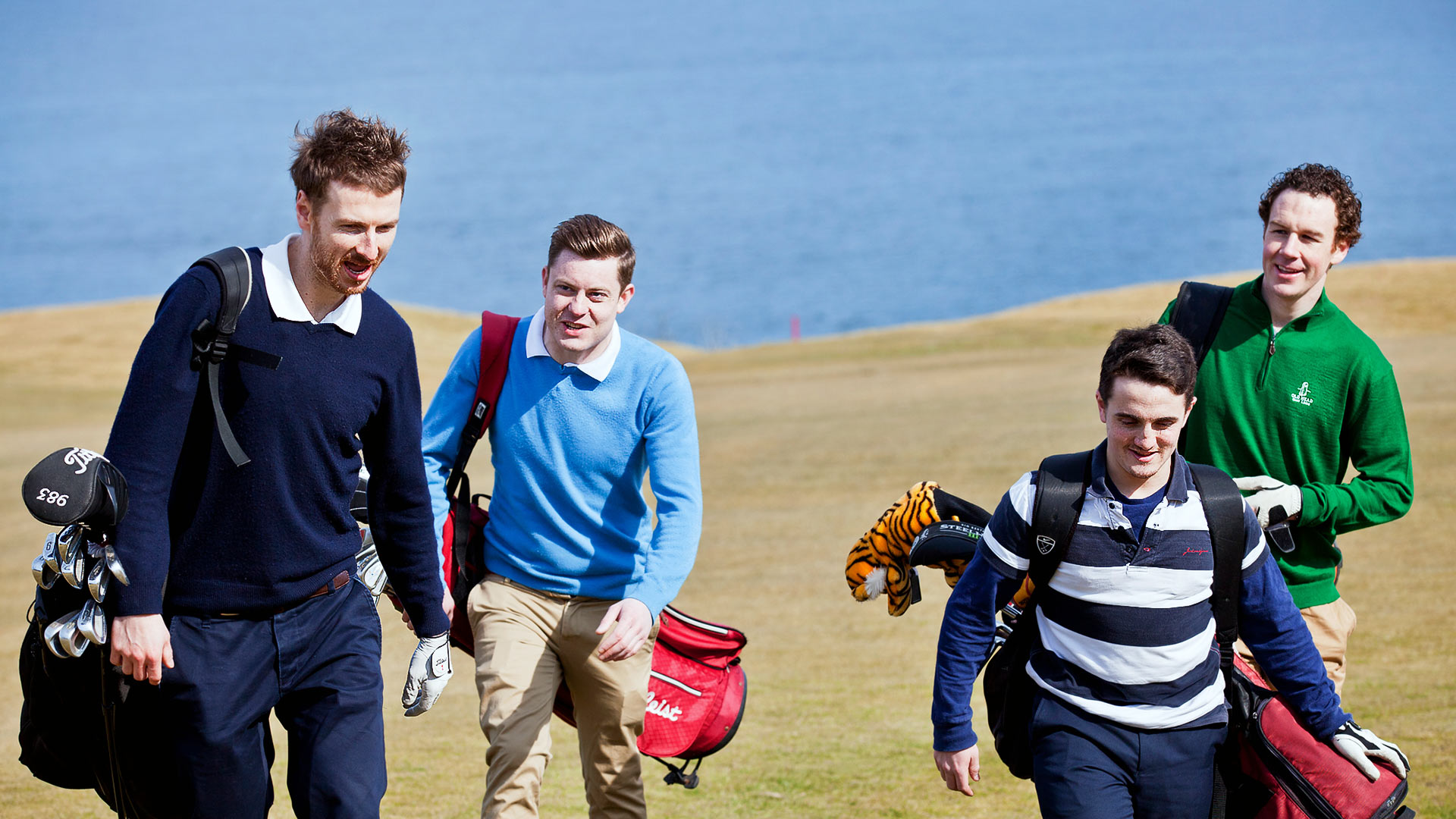 A group of people carry golf bags and clubs for a game of golf in Cork