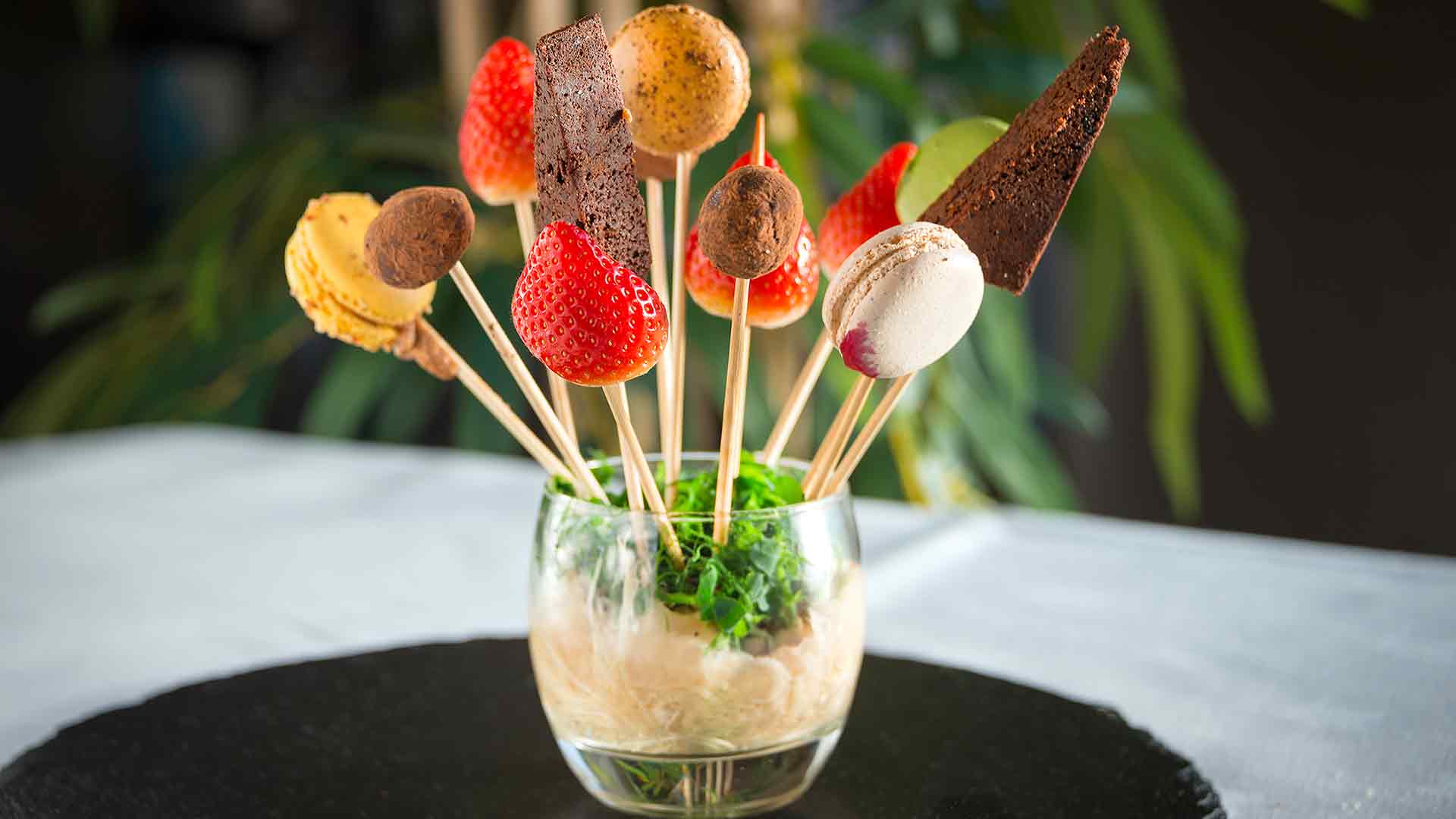 Assortment of sweet treats, macaroons and strawberries on sticks